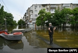 Местный житель на затопленной улице в Херсоне. Украина, 10 июня 2023 года