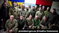 Президентът на Украйна Володимир Зеленски (в центъра) по време на среща с военнослужещи в Херсонска област, които участват в отбраната на региона, 23 март 2023 г.