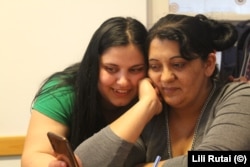 At the school run by the Taleta NGO in Budapest, Anita (left) shows something on her phone to Rozina (right).