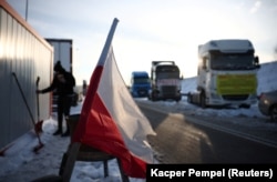 Польський прапор майорить на тлі блокади протестувальників поблизу польсько-українського кордону на пункті пропуску Гребенне- Рава-Руська в Гребенному, Польща, 8 січня 2024 року