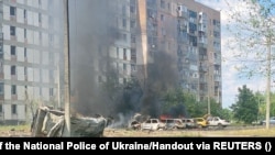 Cars burn at the site of a Russian military strike in the town of Pervomayskiy, Kharkiv region, Ukraine, on July 4.
