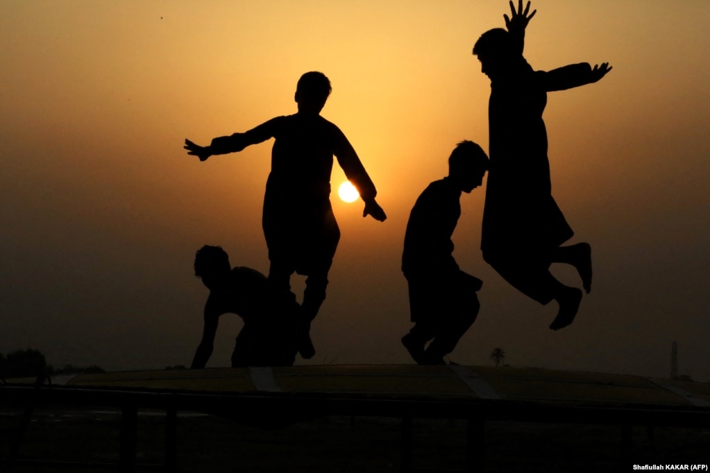 Siluetat e djemve afganë teksa kërcejnë në një trampolinë në Xhalalabad.