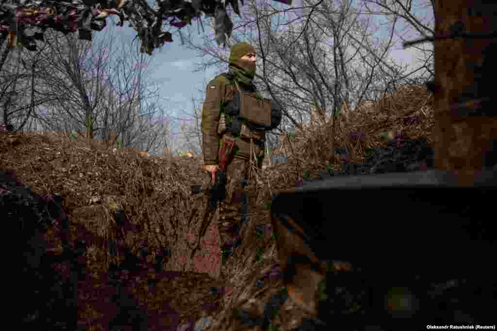 A Ukrainian soldier stands guard by a trench at a position outside the frontline town of Avdiyvka, Donetsk region, Ukraine.