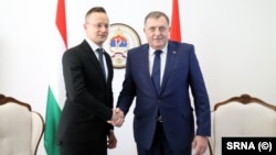 Hungarian Foreign Minister Peter Szijjarto (left) and Bosnian Serb leader Milorad Dodik shake hands at a meeting last year.