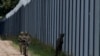 Polish soldiers patrol along the border fence on the Polish-Belarusian border in Usnarz Gorny.