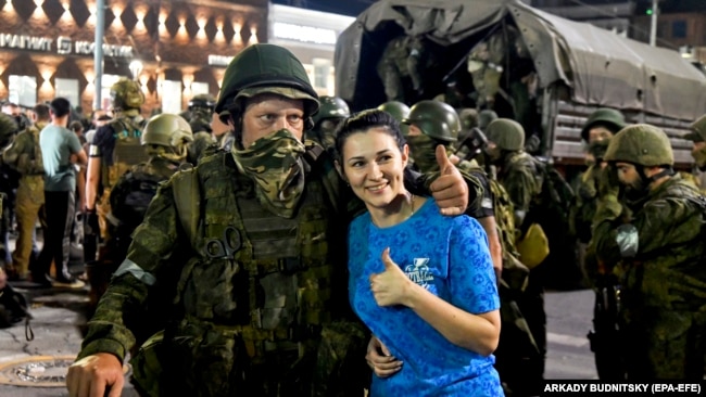 Una donna posa con un combattente del gruppo Wagner mentre si prepara a lasciare il centro di Rostov-sul-Don, nel sud della Russia, il 24 giugno.