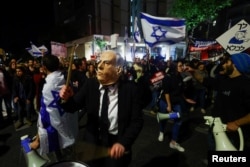 Манифестант в маске Биньямина Нетаньяху во время протестной демонстрации. Иерусалим, 11 марта 2023 года