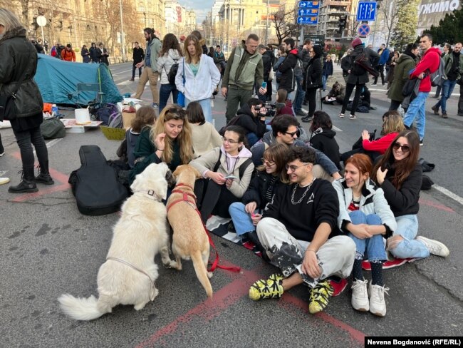 Studentë dhe aktivistë të rinj bllokojnë rrugën në qendër të Beogradit, duke kërkuar hapjen e listës së votuesve për shkak të mashtrimit të supozuar zgjedhor.