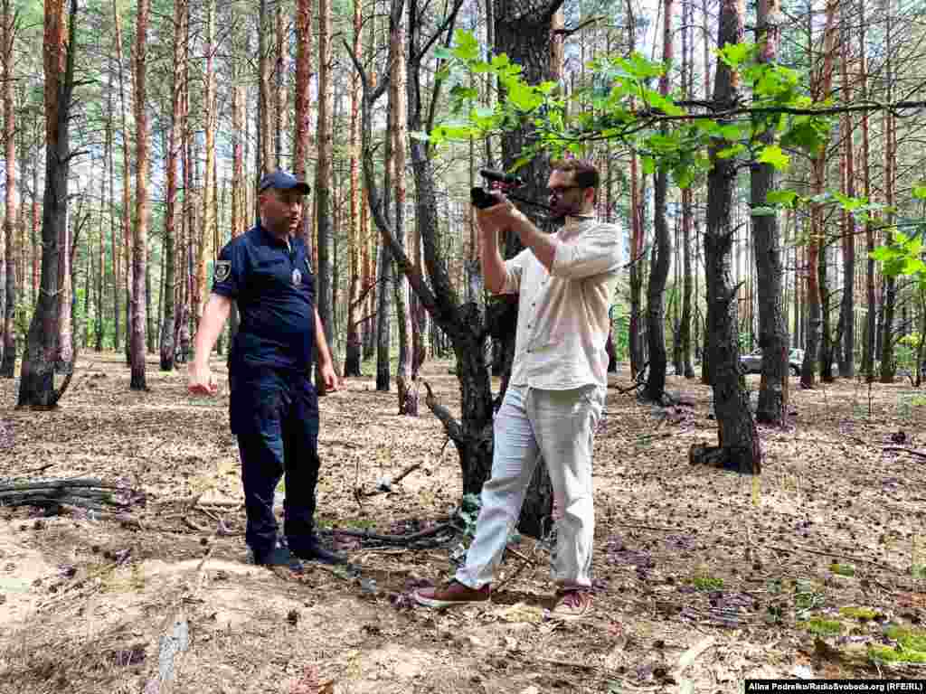 Журналіст Радіо Свобода Дмитро Джулай у лісі на околиці Бучі біля ями, в якій після російської окупації виявили тіла трьох цивільних чоловіків, серпень 2023 року. Інформація про це стала частиною документального фільму &laquo;Буча: хто вбивав та катував? Нові обличчя&raquo;