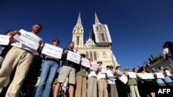 Aktivisti i aktivistkinje u Hrvatskoj ispred Zagrebačke katedrale nose imena žrtava u Ahmićima u znak protesta protiv dočeka Darija Kordića u zračnoj luci u Zagrebu, jun 2014. 