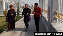 Döwlet binalarynyň biriniň öňünden geçip barýan raýatlar (Illýustrasiýa suraty)