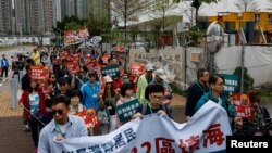 A tüntetőknek számozott zsinórt kell viselniük a nyakukban, miközben egy hulladékátrakó állomás létesítése ellen tiltakoznak az egyik első olyan tüntetésen, amelyet hivatalosan is jóváhagytak az átfogó nemzetbiztonsági törvény hatálybalépése óta Hongkongban. 2023. március 26.