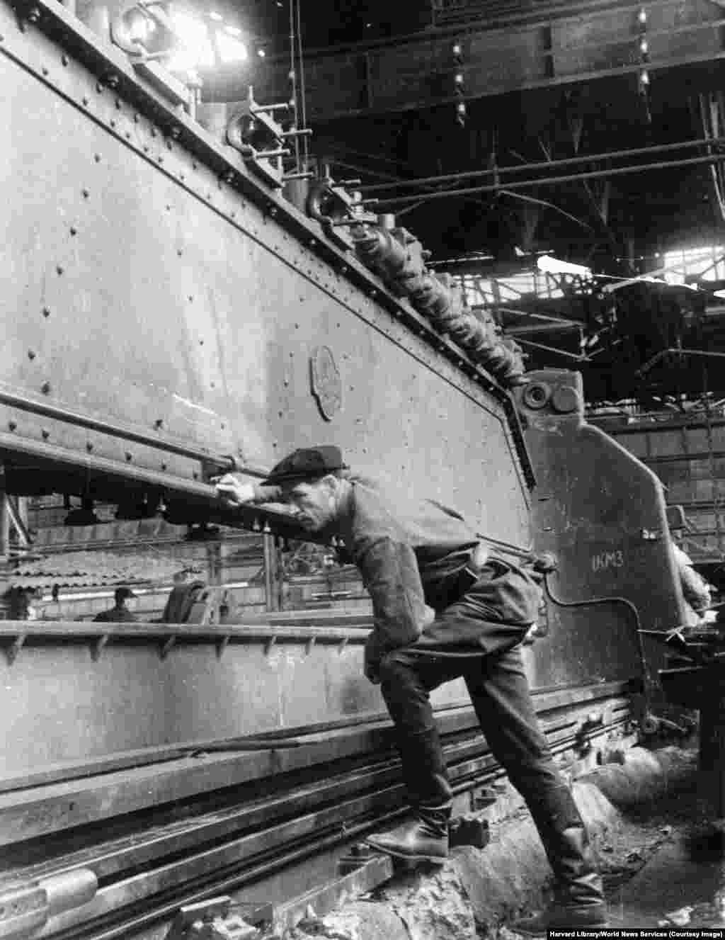 Un mecanic verifică un ansamblu de mașini grele în timpul restaurării Uzinei Stalin din Kramatorsk, la finalul anilor 1940. După cum arată un raport declasificat al CIA din 1952, uzina a fost distrusă în război în proporție de 80% și a reluat producția în mai 1949.