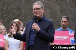 Лидер лейбористов Кир Стармер выступает перед публикой возле местного паба в городке Милтон Кейнс на юго-востоке Англии. 1 июля 2024 года