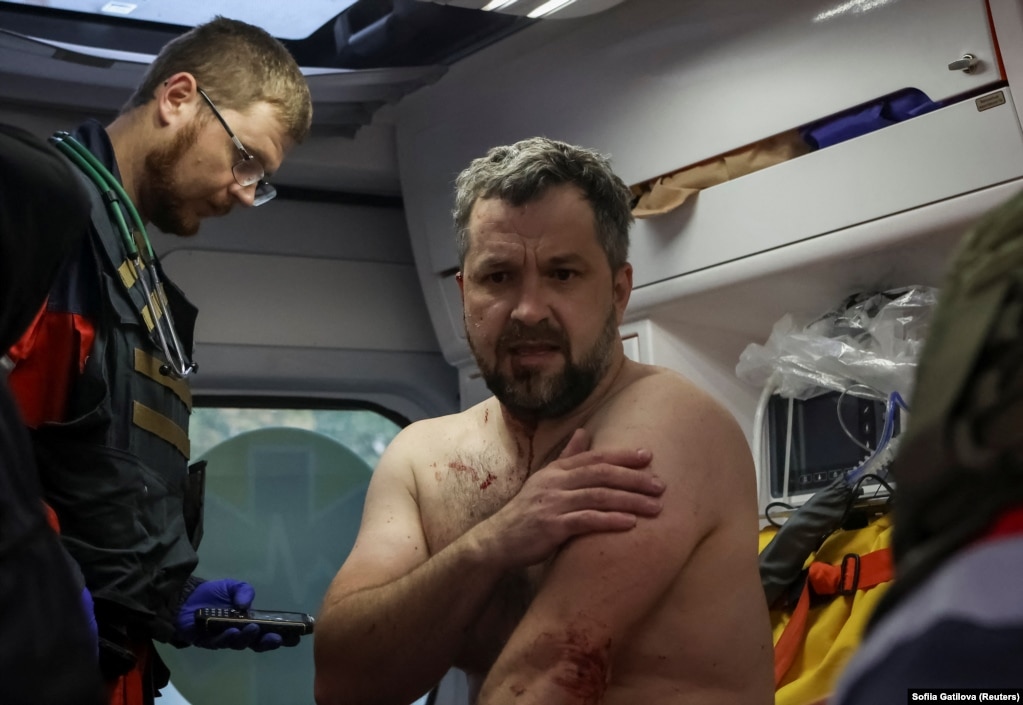  L'uomo ferito viene curato nel retro di un'ambulanza.