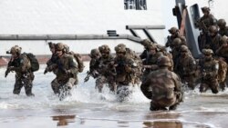 French troops disembark from a U.S. landing craft&nbsp;showcasing an amphibious landing on Omaha Beach on June 4 ahead of 80th anniversary D-Day ceremonies in Saint-Laurent-sur-Mer. The drill was held at a time when French President Emmanuel Macron is considering sending military instructors from his country to Ukraine.