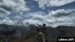 Ukrán katona RPG-vel lő az orosz állások irányába a frontvonalon, Bahmut közelében 2023. május 22-én