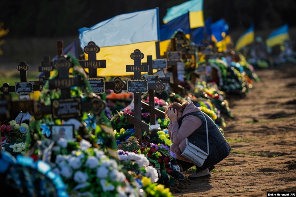 Një varrezë në Mikolaiv, në jug të Ukrainës, nga tetori 2022, shfaq një grua duke vajtuar pranë varrit të djalit të saj të vetëm; një ushtar i vrarë nga bombardimet ruse.