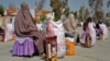 Afghan women sit after receiving food aid distributed by a charity foundation during the Muslim holy fasting month of Ramadan in Kandahar on March 28.