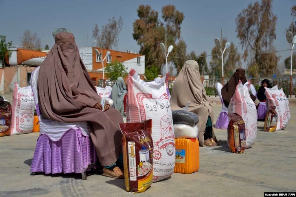Afghan women sit after receiving food aid distributed by a charity foundation during the Muslim holy fasting month of Ramadan in Kandahar. (file photo)