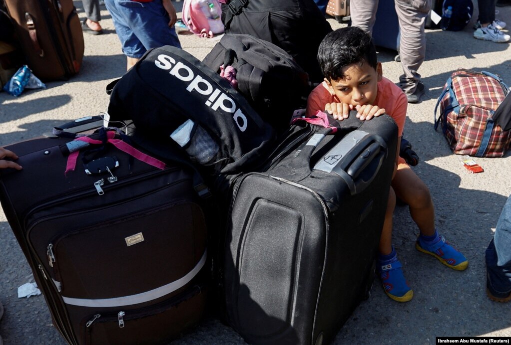 Një fëmijë pushon ulur në valixhe. Palestinezët me shtetësi të dyfishtë janë mbledhur jashtë pikës kufitare Rafah me Egjiptin me shpresën për të marrë leje për t'u larguar nga Gaza, në mes të konfliktit të vazhdueshëm izraelito-palestinez, në Rafah në Rripin jugor të Gazës, 16 tetor 2023.