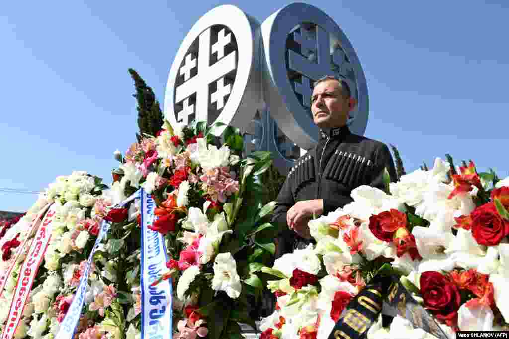 Militar din garda de onoare georgiană în cadrul unei ceremonii de comemorare la un cimitir din Tbilisi pe 8 august pentru soldații georgieni uciși în timpul războiului din 2008 cu Rusia, acum 15 ani.