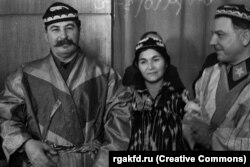 Іосіф Сталін і Клім Варашылаў у таджыкскай нацыянальнай вопратцы разам з таджыкскай калгасьніцай, 1935