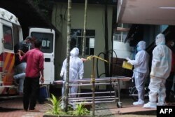 Zdravstveni radnici nose zaštitnu opremu dok prebacuju ljude koji su bili u kontaktu sa osobom zaraženom virusom nipah u centar za izolaciju u vladinoj bolnici u Kožikodeu, u indijskoj državi Kerala 14. septembra 2023.