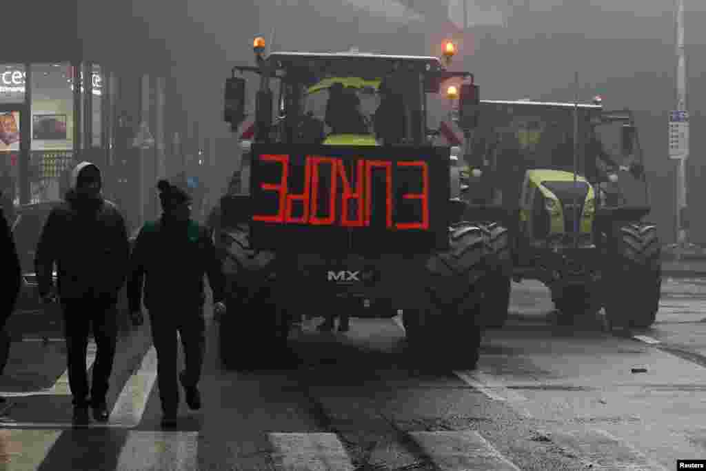 Ljudi prolaze pored traktora tokom protesta evropskih farmera zbog pritiska na cijene, poreza i zelenih propisa, na dan sastanka ministara poljoprivrede EU u Briselu, Belgija, 26. februara 2024.