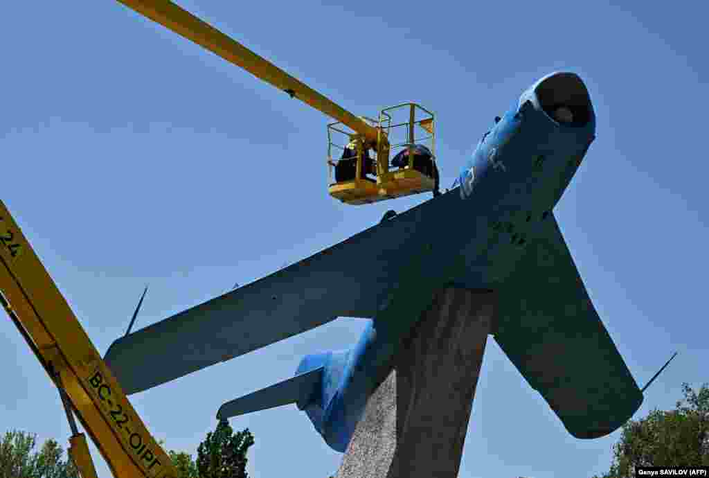 Municipal workers paint a fighter aircraft MiG-17Pf on a Soviet-era monument in the town of Kramatorsk, Donetsk region, Ukraine.&nbsp;