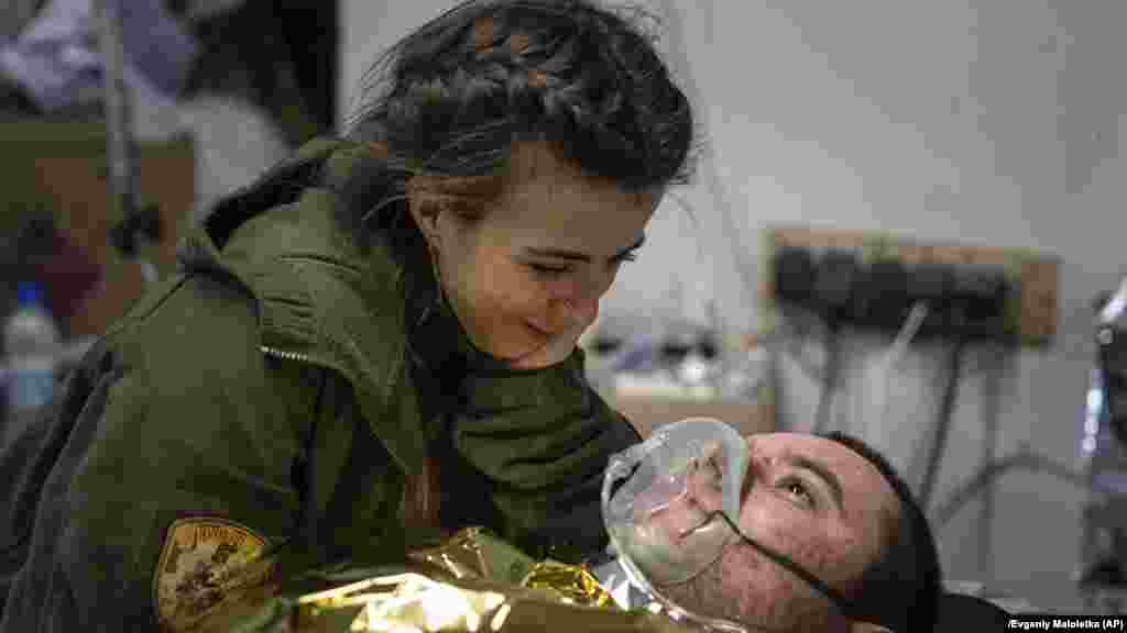 Një mjeke ukrainase duke inkurajuar një ushtar të plagosur.