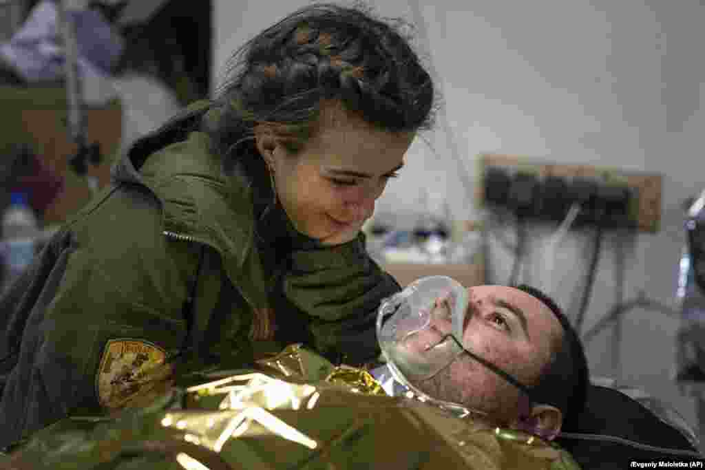 A Ukrainian medic comforts an injured soldier.