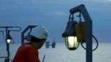 Un muncitori al OMV Petrom privește către o platformă a companiei. Societatea, alături de o firmă de stat românească, ar trebui să exploateze din 2027 gazele din Marea Neagră. 