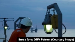 Un muncitori al OMV Petrom privește către o platformă a companiei. Societatea, alături de o firmă de stat românească, ar trebui să exploateze din 2027 gazele din Marea Neagră. 