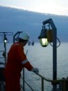 Un muncitori al OMV Petrom privește către o platformă a companiei. Societatea, alături de o firmă de stat românească, ar trebui să exploateze din 2027 gazele din Marea Neagră. 