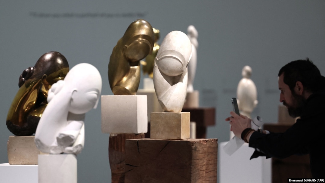 Un vizitator face o fotografie lucrărilor artistului român Constantin Brâncuși în timpul avanpremierii retrospectivei desfășurate la Centrul Pompidou. 26 martie 2024. 