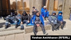 Oil workers from Zhanaozen sit in front of the Kazakh Energy Ministry for a second day of protests in Astana on April 11.