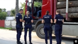 Polițistele și un polițist din Neamț verifică un camion suspectat că are surplus de bușteni, în localitatea Poieni.