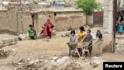 گروهی از کودکان در یک منطقهٔ سیلاب زده در ولایت بغلان. سیلاب های اخیر زنده گی تعداد زیادی از کودکان را با خطر مواجه ساخته است