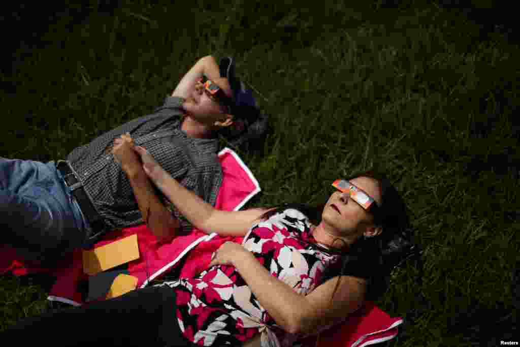 Par nosi posebne zaštitne naočale dok posmatra pomračenje Sunca u parku Bicentenario u Antiguo Cuscatlanu, El Salvador, 14. oktobra.