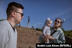 Karyna and Oleh Kublenka brought their son Mykyta to look at the river flooding an area stretching kilometers away from Kherson.