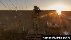 Një ushtar ukrainas duke vëzhguar nga pozicioni i tij në rajonin Herson, nëntor 2023.