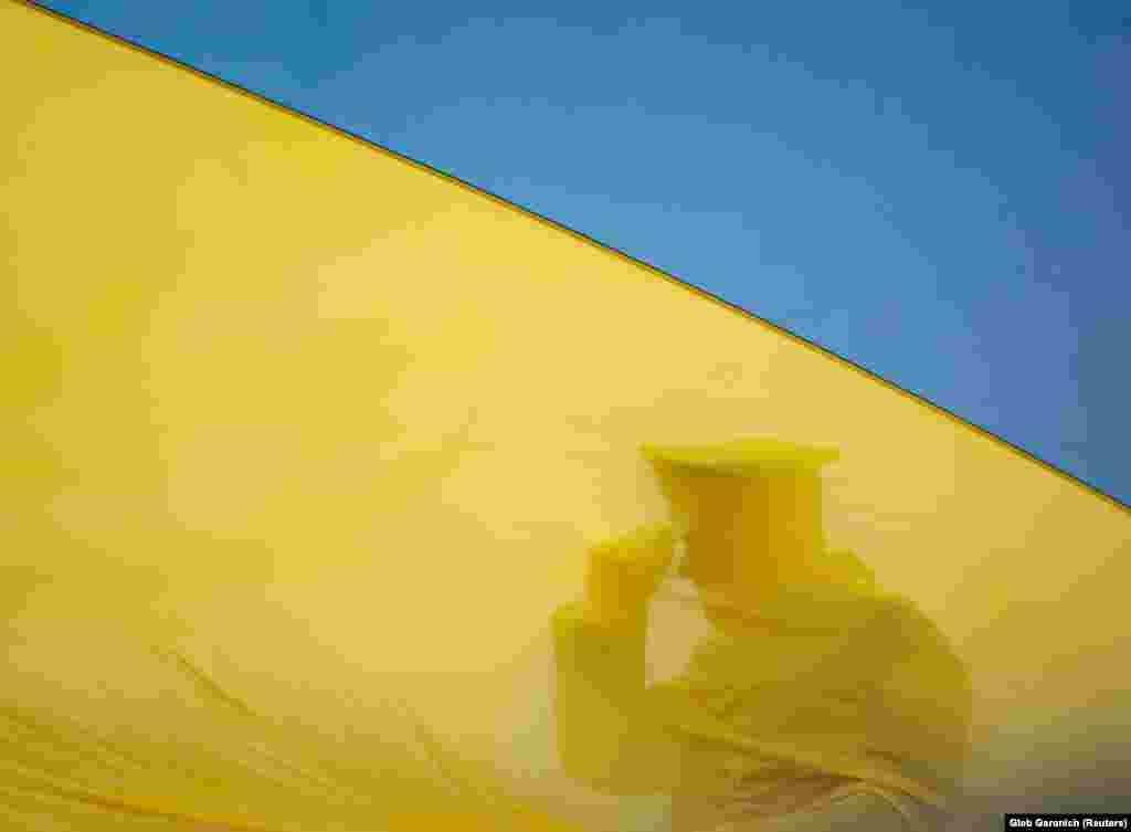 A member of the Honor Guard is seen behind Ukraine&#39;s national flag during a ceremony to mark the first anniversary of the liberation of the town of Bucha from Russian forces on March 31.