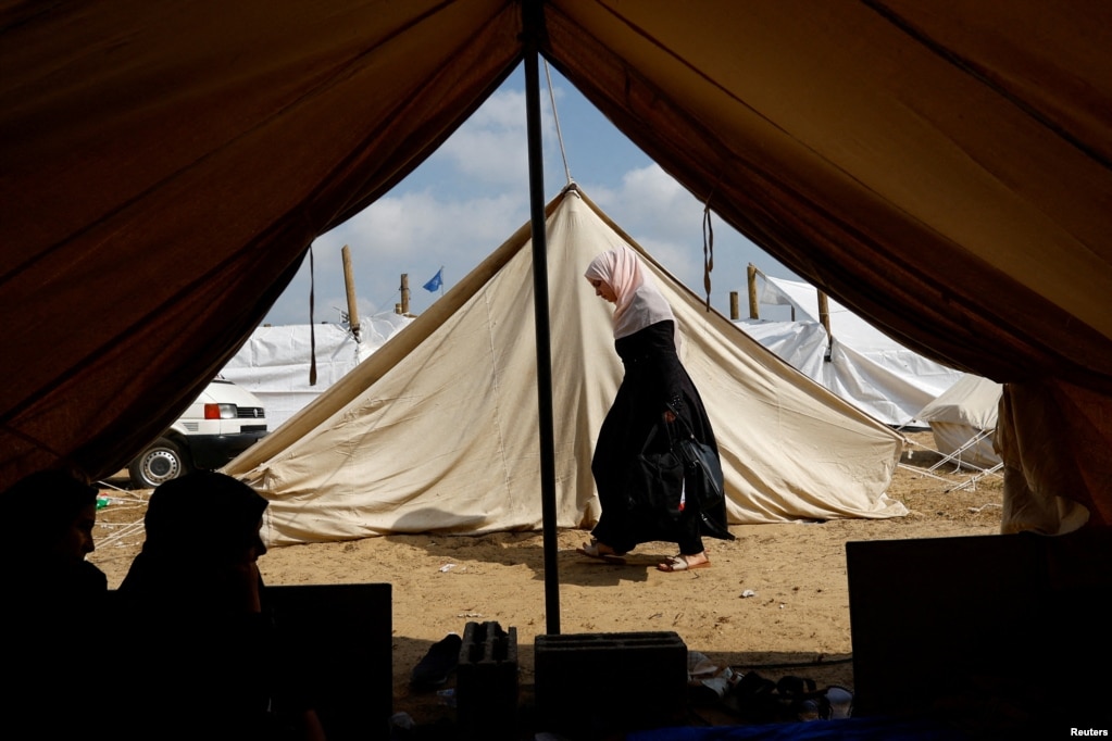 Një grua kalon pranë tendave në një kamp të ngritur. Palestinezët që u larguan nga shtëpitë e tyre mes sulmeve izraelite, strehohen në kampin me tenda të drejtuar nga Kombet e Bashkuara, pas thirrjes së Izraelit për më shumë se 1 milion civilë në Gazën veriore që zhvendosen në jug, në Han Junis.