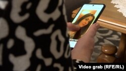 Sevda Kadić drži mobitel na čijem je zaslonu fotografija njene ubije kćerke Alme, april 2023. 