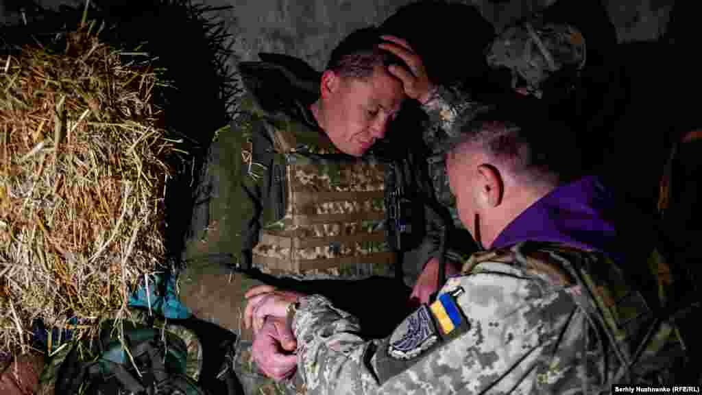 Oleksandr, a military chaplain, blesses a Ukrainian soldier in the Kharkiv region on April 24, 2022.