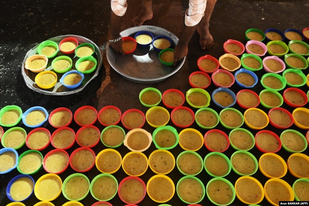 Një besimtar mysliman përgatit kupa me ushqime për iftar në xhaminë Wallajah në Çenai, Indi.