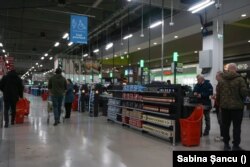 O seară de luni calmă, la hipermarketul Auchan din Brașov. Aproape toate casele sunt deschise, iar mulți asistenți explică oamenilor cum funcționeazză casele self-checkout. Nu sunt cozi.