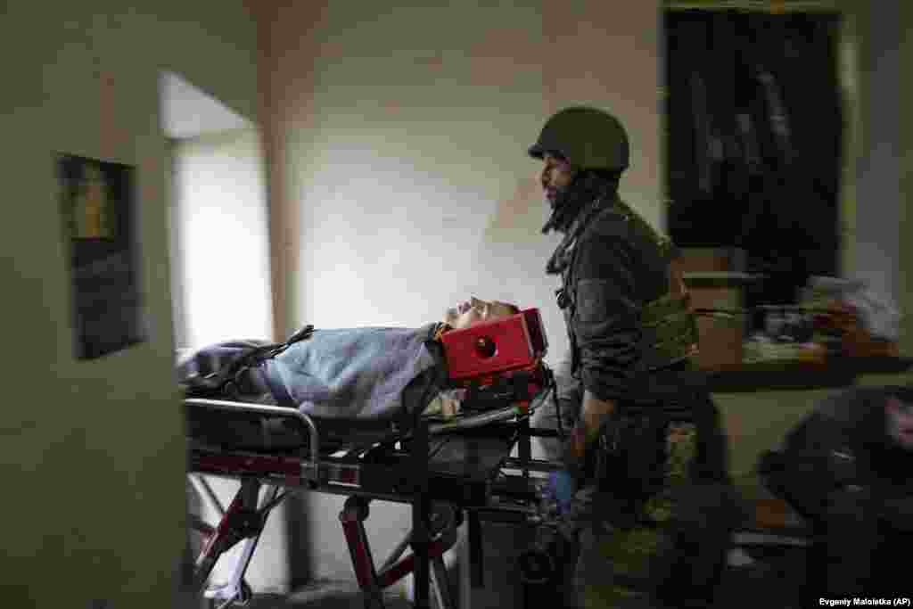 Një mjek ushtarak duke shtyrë barelën me një ushtar të plagosur. Analistët thonë se kapja e Bahmutit, i cili është shkatërruar pothuajse plotësisht nga luftimet, do të kishte pak rëndësi strategjike për Rusinë, por se Moska do t&#39;i jepte rëndësi simbolike në përpjekje për të rritur moralin e ushtarëve.