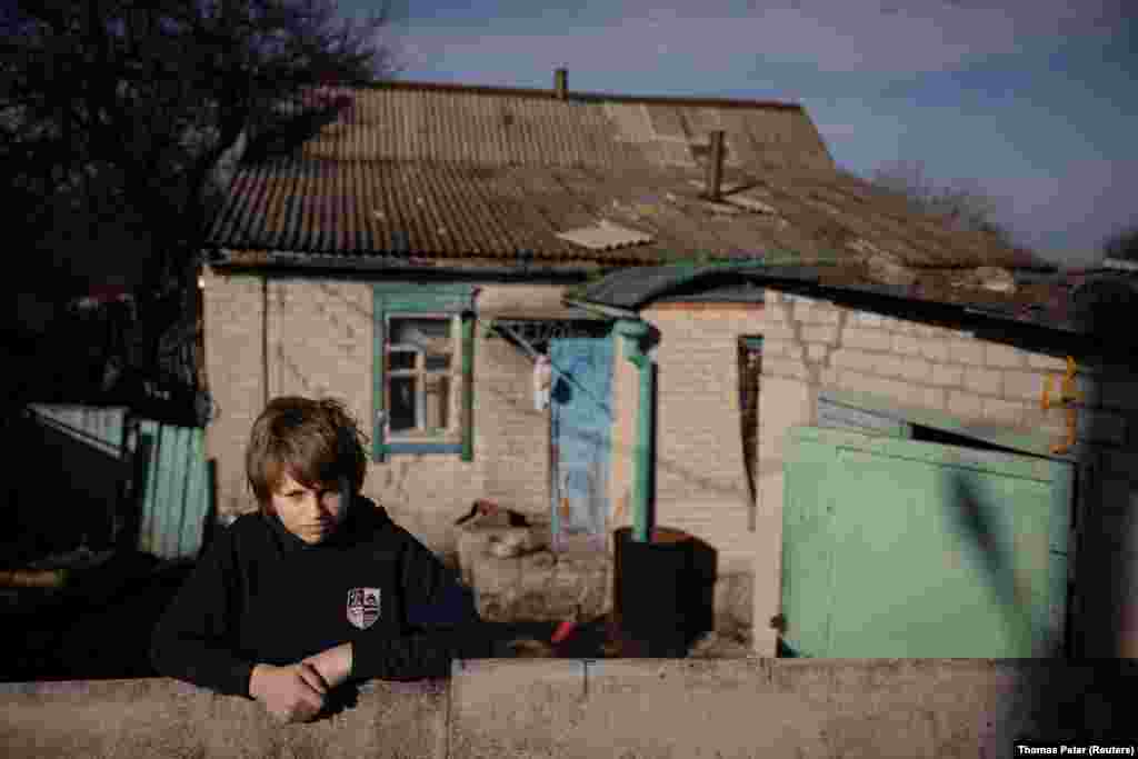 Mykyta, a 13-year-old with learning disabilities, waits outside his home in the village of Tetyanivka, less than 30 kilometers from the raging war in Ukraine&#39;s Donetsk region. For children such as Mykyta who live near the front, the volunteers who come several times a week are a lifeline, offering the only interaction they will receive outside of their immediate families. &nbsp;